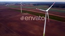 Windmill Wind Turbines Spinning Generating Renewable Electric Energy in Field
