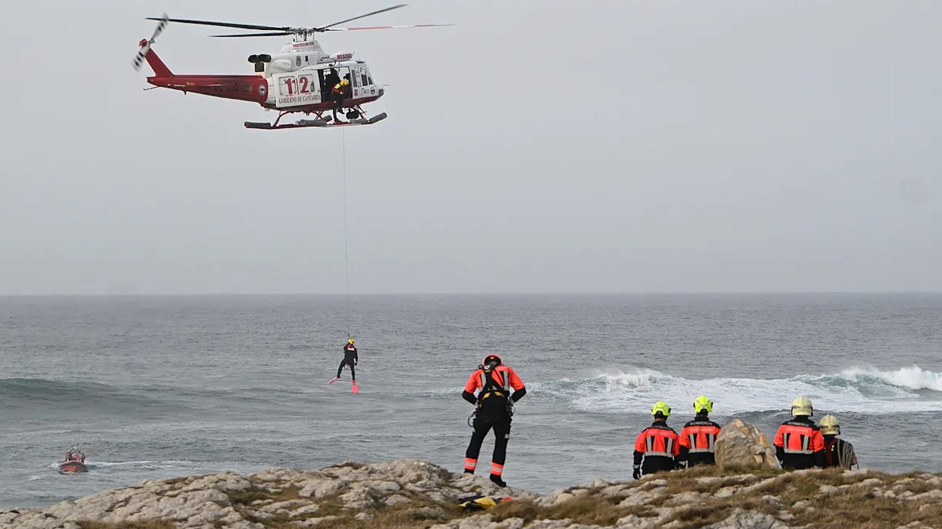 La ciudad de Santander se encuentra conmocionada tras el grave accidente ocurrido este lunes en la zona costera de El Bocal. Lo que comenz� como una tarde de senderismo para un grupo de siete j�venes termin� en una cat�strofe cuando una de las pasarelas de madera que une los acantilados se hundi�, precipitando a todos los integrantes al mar y a una zona de rocas escarpadas.
El Centro de Atenci�n a Emergencias 112 recibi� el aviso cerca de las 16:45 horas, activando de inmediato un despliegue masivo por tierra, mar y aire. Seg�n los datos confirmados, en la estructura se encontraban siete personas realizando una ruta hacia el Instituto Espa�ol de Oceanograf�a en el momento del colapso. El balance actual es desolador: cuatro fallecidos confirmados, dos personas que permanecen desaparecidas y una �nica superviviente que fue rescatada con signos de hipotermia.
Una de las v�ctimas mortales fue trasladada inicialmente en estado cr�tico a la UVI del Hospital Universitario Marqu�s de Valdecilla, donde lamentablemente falleci� poco despu�s. La alcaldesa de la ciudad, Gema Igual, presente en el Puesto de Mando Avanzado, calific� lo sucedido como "una gran desgracia porque un grupo de siete j�venes que ven�an a disfrutar de la naturaleza se han encontrado con este accidente".
A pesar de que las condiciones de la mar son adversas y la falta de luz dificulta las tareas tras el atardecer, los servicios de emergencia mantienen la operatividad a su m�ximo nivel. El dispositivo cuenta con la participaci�n de Salvamento Mar�timo, Guardia Civil, Bomberos de Santander, drones y helic�pteros del Gobierno de Cantabria.
La regidora santanderina ha expresado su deseo de encontrar pronto a los dos j�venes que faltan, manifestando que "ojal� esas dos b�squedas no acaben siendo v�ctimas", aunque ha reconocido que la situaci�n es extremadamente compleja. No obstante, ha asegurado que "no se va a cejar tampoco de buscar" en el agua hasta que se agoten todas las posibilidades.
La pasarela siniestrada se ubica sobre un regato de agua entre dos acantilados y depende del �rea de Costas del Ministerio de Medio Ambiente. Gema Igual ya se ha puesto en contacto con el secretario de Estado de Medio Ambiente, Hugo Mor�n, quien se desplaza a la capital c�ntabra para evaluar el estado de la instalaci�n.
Ante la gravedad de los hechos, la alcaldesa ha pedido prudencia y ha evitado dar detalles sobre el origen de las v�ctimas por respeto a su privacidad. Asimismo, ha hecho un llamamiento a la unidad institucional: "Debemos dar datos certeros y ponernos en el caso de los familiares y de las v�ctimas. Estamos hablando de seres humanos y vidas", se�al�, a�adiendo la petici�n de que "por favor, que la pol�tica no manche el objetivo principal, que es poder recuperar a los supervivientes, si los hay, y poder atender a las familias". El Ayuntamiento ha habilitado el Centro C�vico Fernando Ateca para brindar asistencia psicosocial a los allegados de los afectados por este tr�gico suceso.