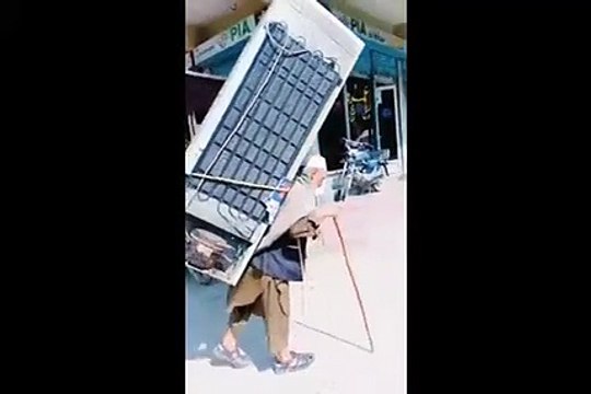 فيديو يوثق تجوّل رجل مسن خارق وعلى ظهره براد ضخم