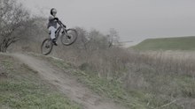 Biker attempts to flat out a jump on a mountain bike trail and lands hard