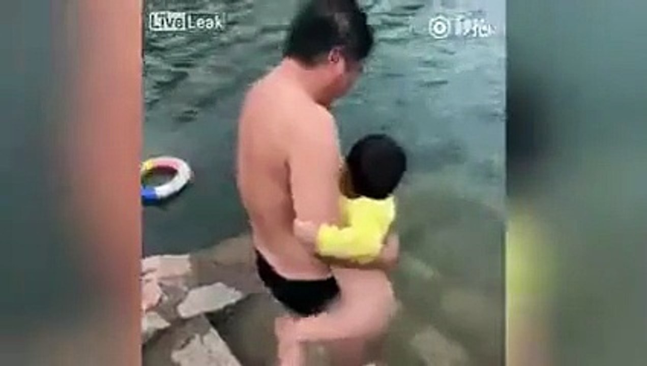 أب يلقي ابنه عاريًا في البحيرة كي يعلمه السباحة .. ويثير الغضب بهذا الفيديو