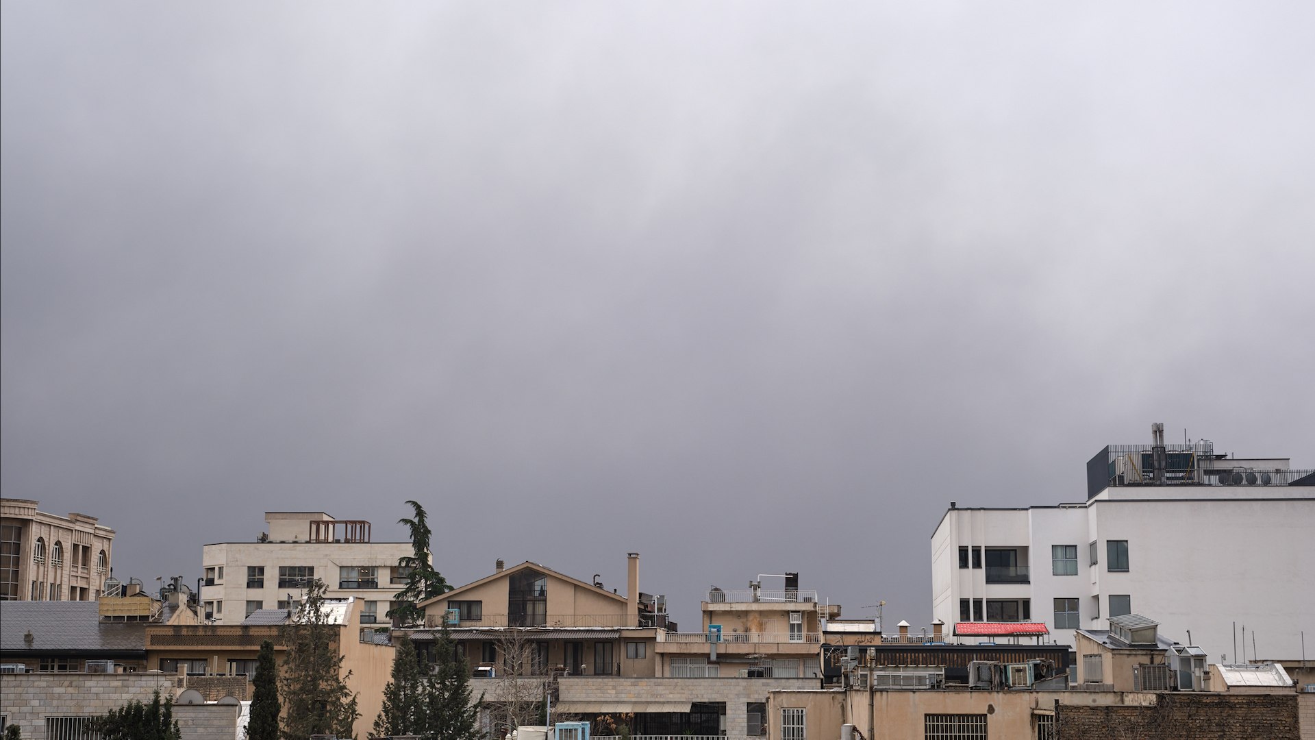 La capital de Ir�n ha despertado este domingo bajo una atm�sfera asfixiante y una estampa casi apocal�ptica. Los intensos bombardeos ejecutados durante la madrugada por las fuerzas israel�es contra infraestructuras energ�ticas han dejado un rastro de contaminaci�n sin precedentes en la ciudad. Seg�n han relatado numerosos testigos, las precipitaciones que han ca�do sobre la metr�poli parec�an "lluvia de aceite", dejando charcos de un color negro intenso y restos de combustible en las calles.
La situaci�n es de tal gravedad que la Organizaci�n de Protecci�n Ambiental de Ir�n ha emitido un comunicado urgente instando a la poblaci�n a permanecer en sus casas debido a la alta toxicidad del aire. La nube t�xica es el resultado directo de los ataques contra cuatro instalaciones de almacenamiento de crudo y un centro de transferencia en las provincias de Teher�n y Alborz.
Keramat Veis Karami, director de la Compa��a Nacional Iran� de Distribuci�n de Productos Petrol�feros, ha confirmado el fallecimiento de cuatro trabajadores, todos ellos conductores de camiones cisterna. El alto cargo describi� el impacto visual de la ofensiva como esos "ataques que hicieron brillar la noche iran� como si fuera de d�a". A pesar de los da�os, las autoridades aseguran que el suministro de gasolina est� garantizado y piden calma para evitar colapsos en las estaciones de servicio.
Desde que el pasado s�bado 28 se iniciaran las hostilidades conjuntas de Israel y Estados Unidos, el balance humano es devastador: m�s de mil iran�es han perdido la vida y miles de edificios han quedado reducidos a escombros. La ofensiva no ha discriminado objetivos, alcanzando desde el palacio presidencial y las oficinas del fallecido l�der supremo, Ali Jamene�, hasta infraestructuras puramente civiles.
El impacto en la poblaci�n civil ha sido especialmente cruento en puntos como la plaza Nilufar, donde un ataque estadounidense provoc� la muerte de 20 personas al alcanzar edificios residenciales cercanos a una base militar. Adem�s, la destrucci�n se ha extendido a centros sanitarios, con al menos dos hospitales golpeados, y al �mbito deportivo, con la demolici�n de un campo de f�tbol sala dise�ado para albergar a 12.000 espectadores.
Mientras el Ej�rcito de Israel sostiene que sus objetivos eran dep�sitos de combustible utilizados exclusivamente por las fuerzas armadas iran�es, la realidad sobre el terreno muestra da�os extensos en servicios b�sicos y zonas densamente pobladas. Teher�n intenta ahora recuperar cierta normalidad bajo un cielo que a media ma�ana todav�a manten�a la oscuridad de la noche debido a las densas columnas de humo y petr�leo quemado.
