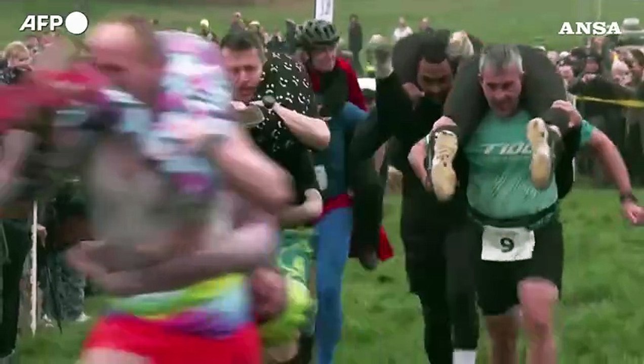 8 marzo in Inghilterra, i mariti corrrono con le mogli sulle spalle a testa in giu'