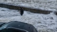 Man's risky attempt to clear a drain as floodwaters surge during Storm Bram