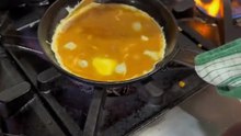 Chef is cooking some buttery scrambled eggs using a folded techni