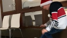 Boy unwraps his Christmas present and reacts excitedly to a new pair of shoes