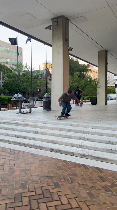 Skateboarder attempts Tre flip from set of five stairs and lands awkwardly on his ankle
