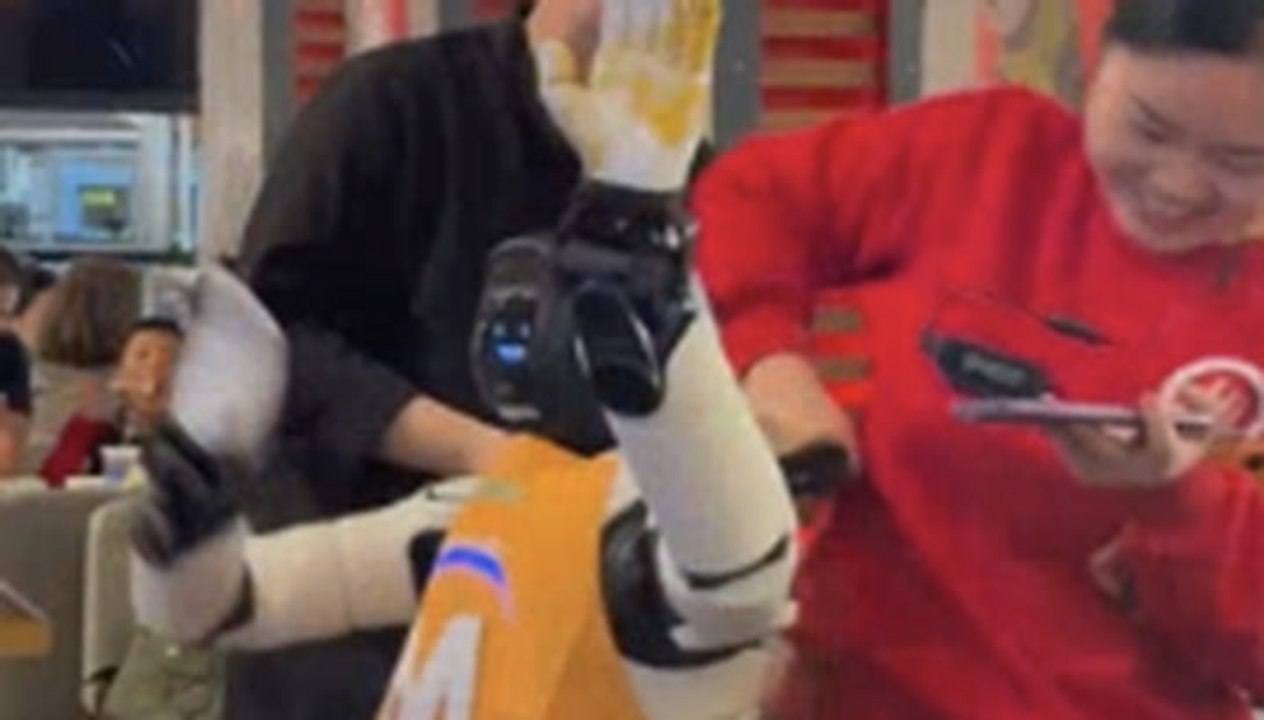 Staff struggle to restrain dancing robot as it...