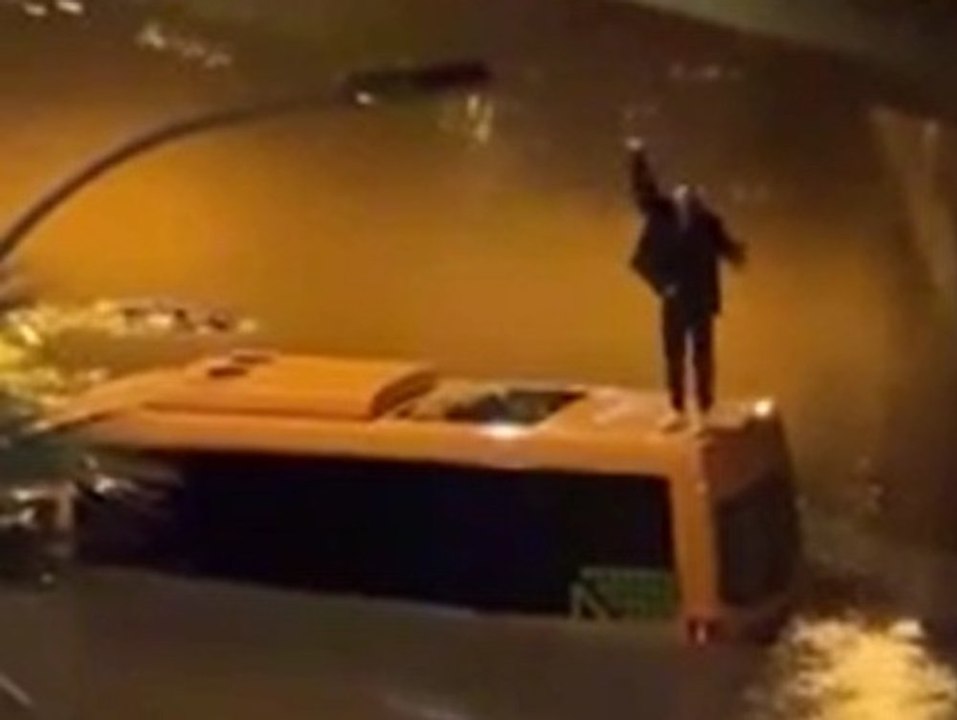 Touristen fliehen vor Wassermassen auf Busdach