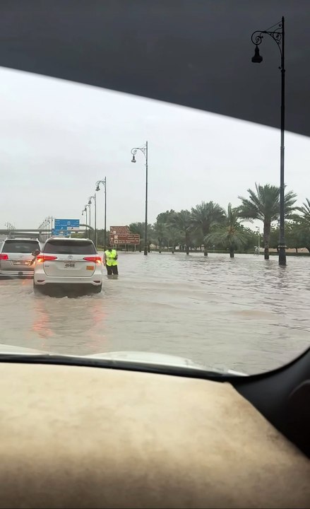 Residents removing large garbage bins blown into the road