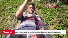 Yol olmayan eve çelik tel üzerinde tehlikeli yolculuk