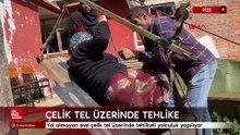 Yol olmayan eve çelik tel üzerinde tehlikeli yolculuk