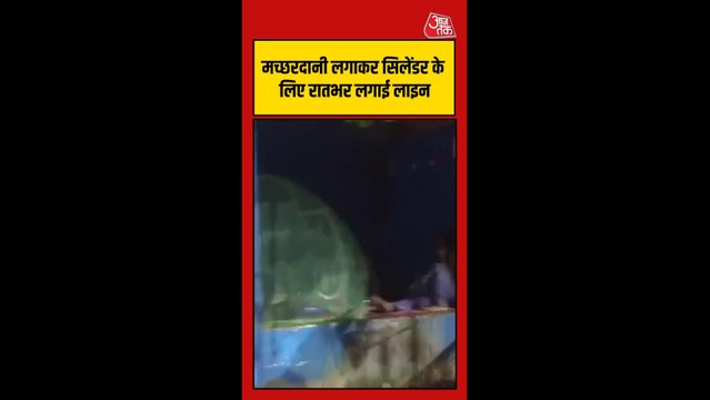 मच्छरदानी लगाकर रात पर सिलेंडर के लिए लाइन में लगा रहा युवक