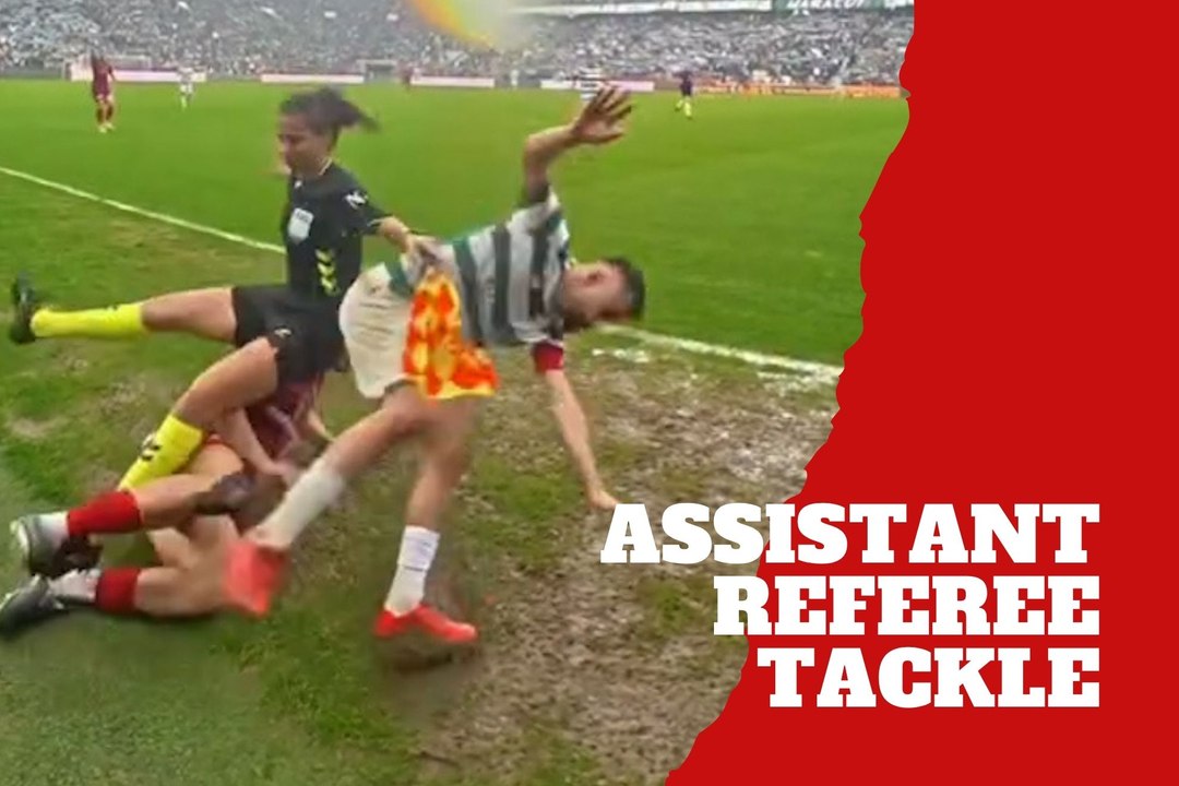 Assistant referee gets tangled up in tackle