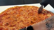Slicing up a large cheese pizza