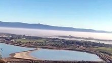 Cagliari, il Poetto avvolto dalla nebbia e la Sella del Diavolo (quasi) scompare