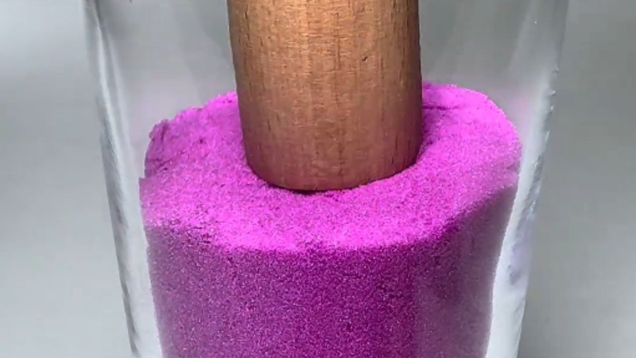 Mesmerizing pattern creation: Vibrant kinetic sand layered seamlessly in glass