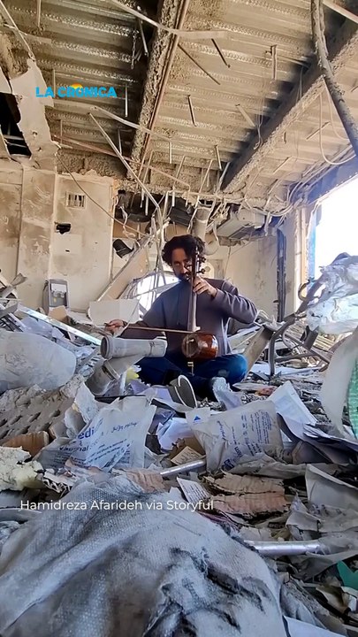Un profesor de música toca entre las ruinas de su escuela destruida en un ataque con drones