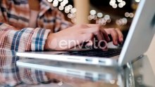 Close-up Woman's Hands Working with Laptop on the Desktop. Girl Blogger Freelancer Works in a Cafe