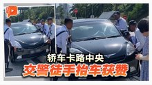 轿车卡路中央 交警徒手抬车获赞