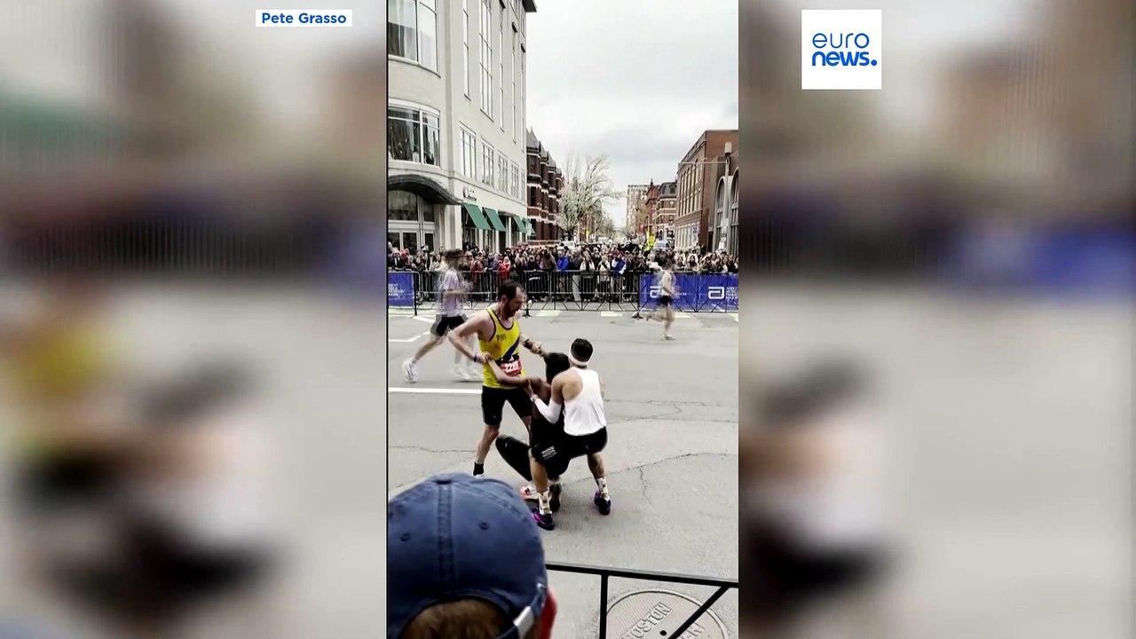 Zwei Läufer helfen zusammengebrochenem Teilnehmer, den Boston-Marathon zu beenden