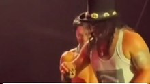 Only at a Guns N’ Roses show: Slash picks up gift thrown by a fan on stage at Castelão and plays along with Axl Rose