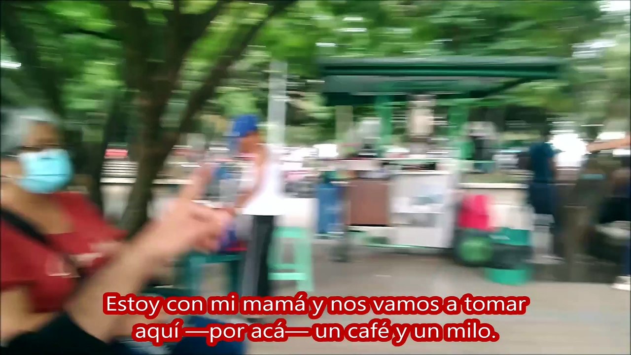 Niña hace su tarea en el parque, mientras su madre trabaja de vendedora informal.