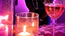 Woman beams with happiness after her partner surprises her with a romantic candlelit dinner during her shift