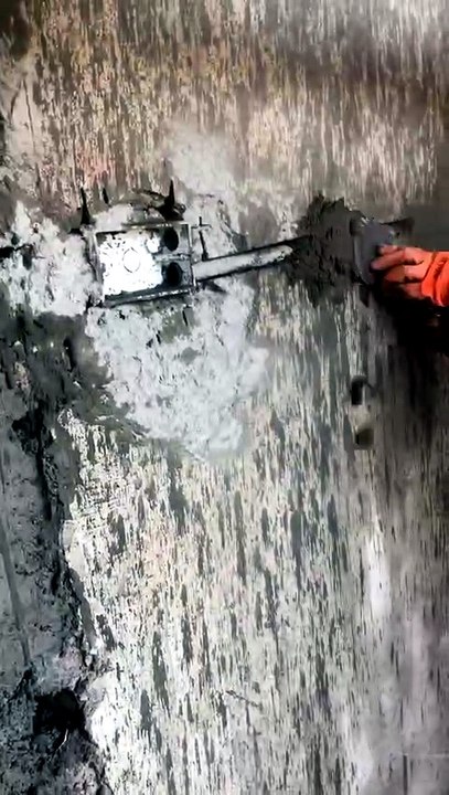 Fixing an electrical board in a brick wall.