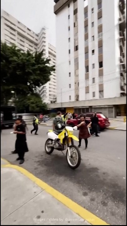 Venezuelans run in and out of apocalyptic dust clouds