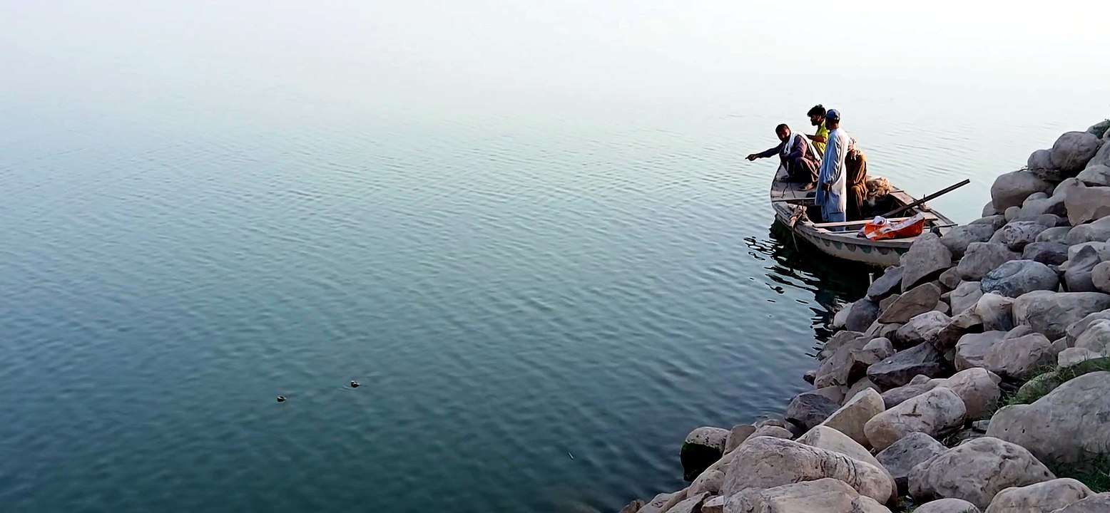 Some fishermen sitting on a boat and catching fish