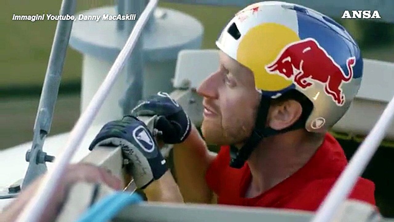 Ciclista acrobatico pedala su una pala eolica contro il cambiamento climatico