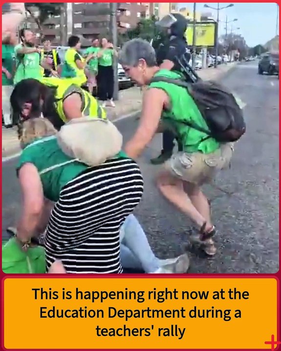 Look at this ultra with a badge, the way he treats that woman.   What a bully.   This is happening right now at the Education Department during a teachers' rally