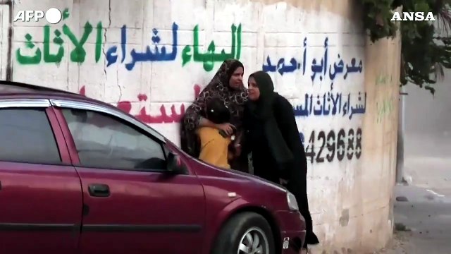 Palestinesi fuggono dopo che un missile distrugge palazzo a Gaza