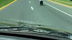 Un homme en fauteuil roulant roule plus vite que les voiture
