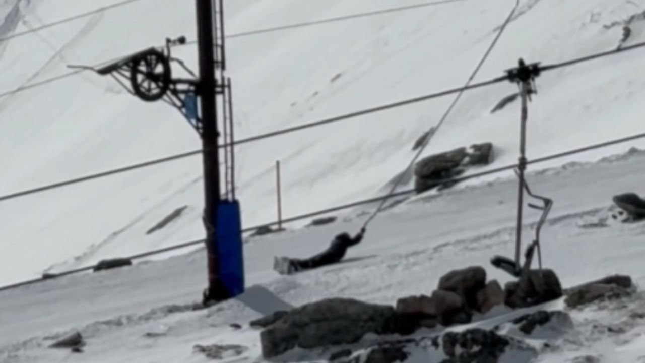 Snowboarder Slides Downhill And Knocks Into Skiers On Tow
