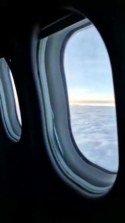 Airplane Window View above the Clouds