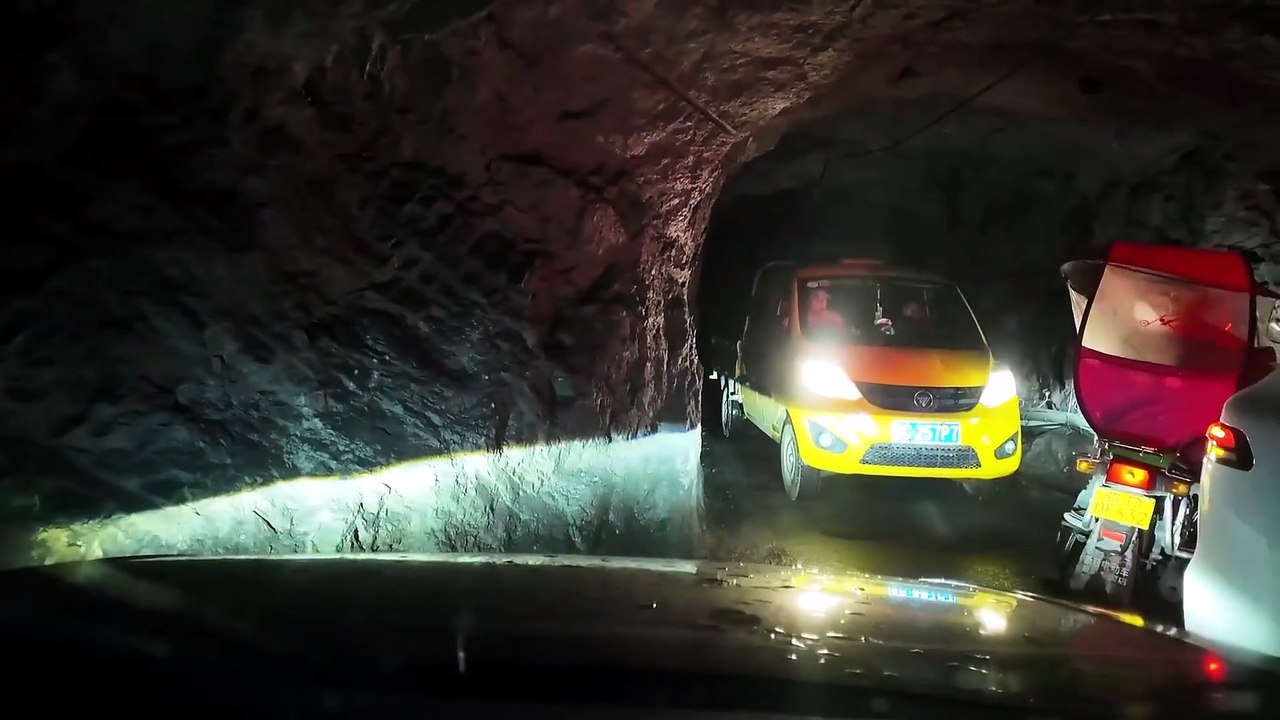 Dans un tunnel étroit taillé dans la montagne, à Chongqing, l’automobiliste filme sa traversée délicate