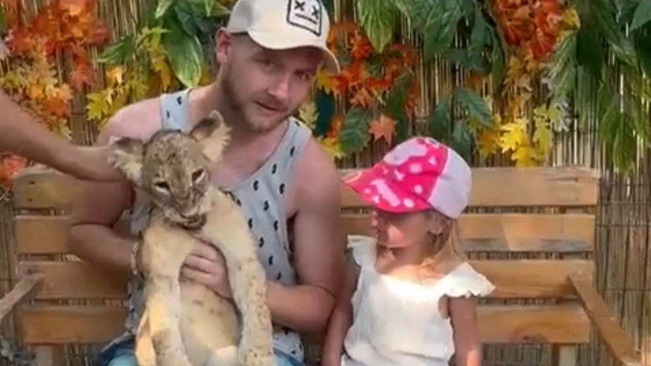 Man captures memories with lion cub until receiving a light nibble