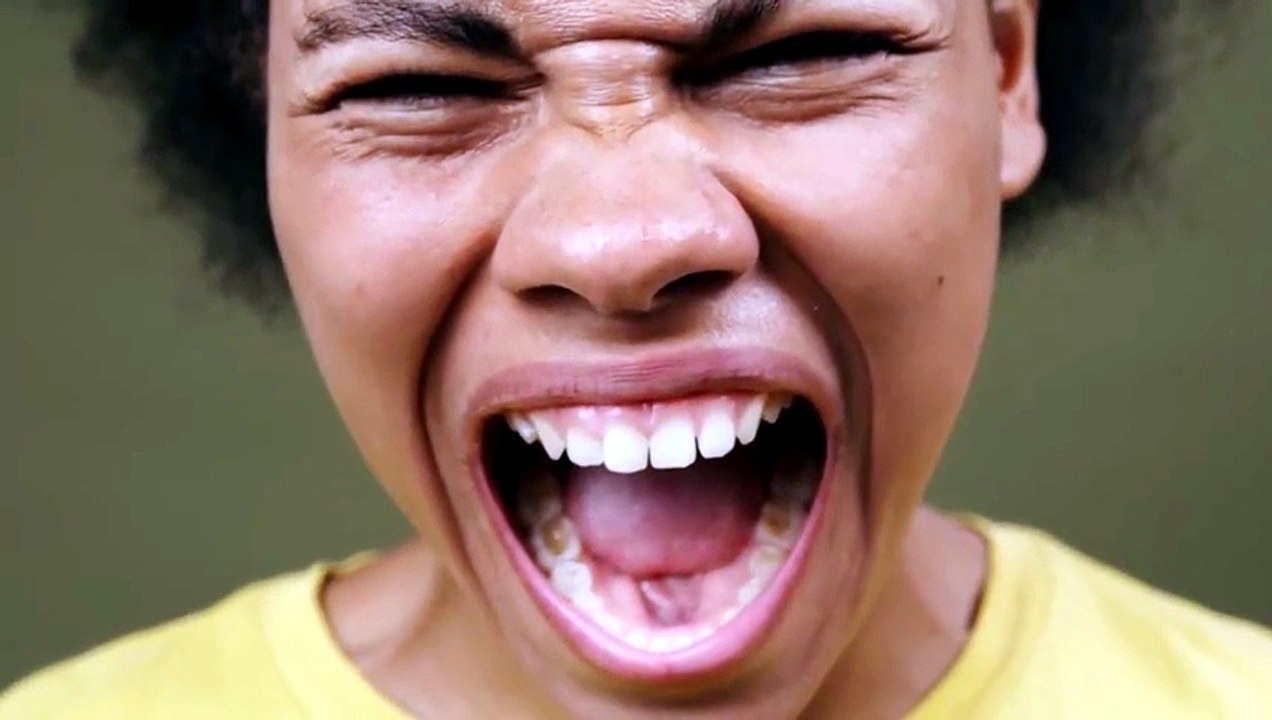 a brunette woman in a yellow t-shirt shouts at the camera - Free Stock Video Explained