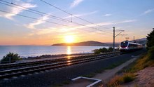 夕方の海沿いの線路を走っている電車