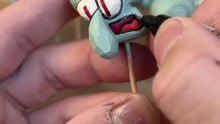 Wood carving of Squidward blowing a trumpet