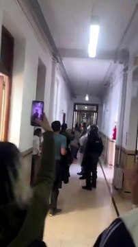 Martín Porro, presidente de la Comisión Nacional de Energía Atómica, sale escoltado de la sede de la CNEA
