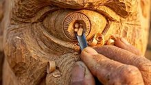 An old man carves a life-size Cyclops from wood.