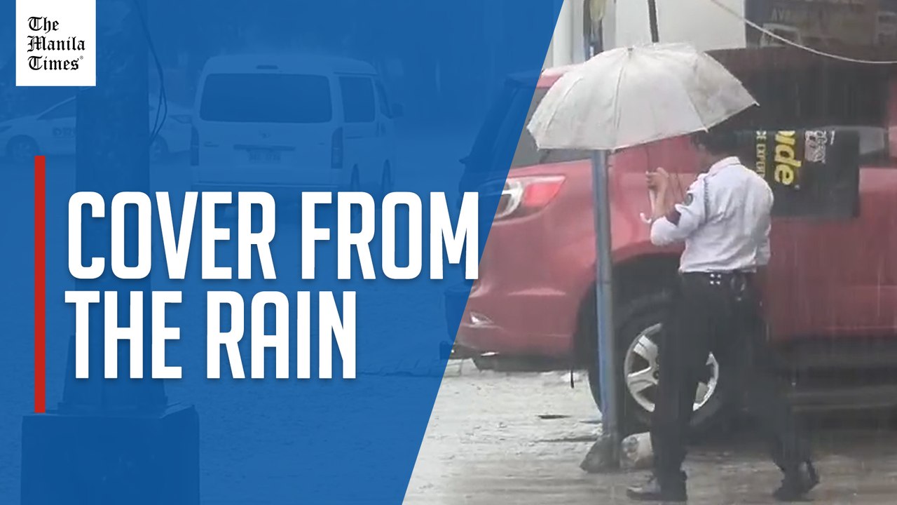 Security guard shields motorists from downpour
