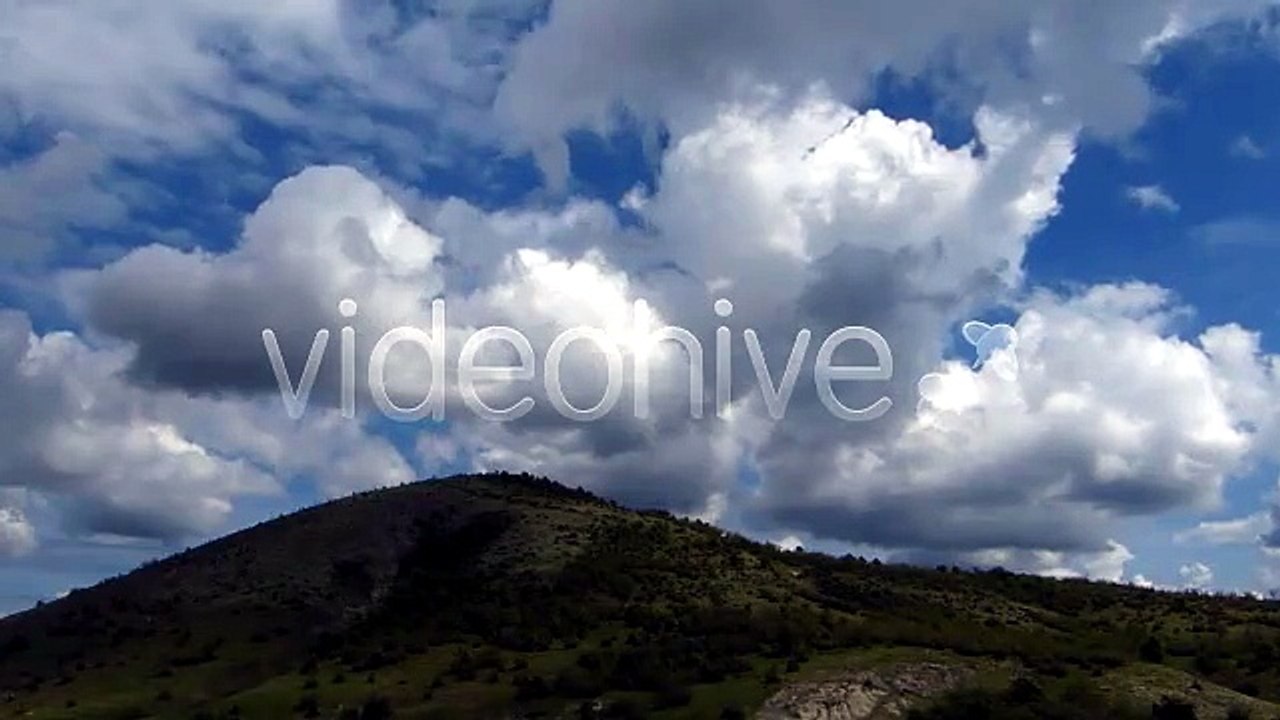 Rolling Green Hills and White Clouds Under Blue Sky