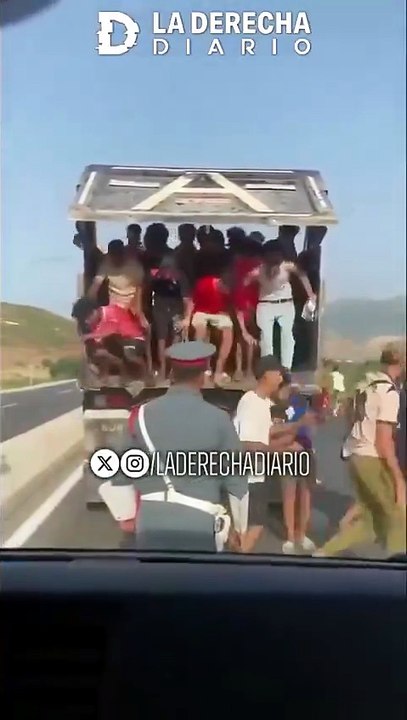 Cientos de inmigrantes ilegales marroquíes bajando de un camión en medio de la ruta tras invadir España a través de la frontera de Ceuta.