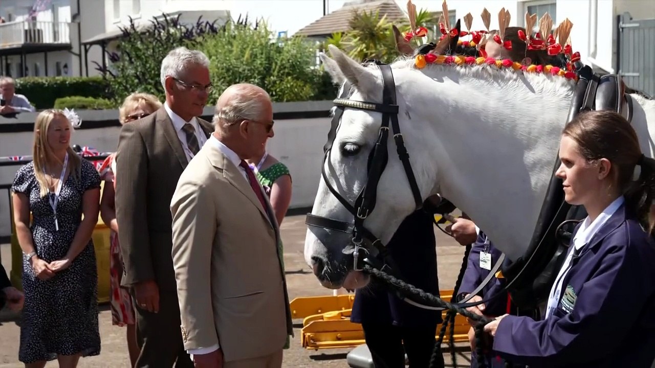 King all smiles as he rides on a horse-drawn tram