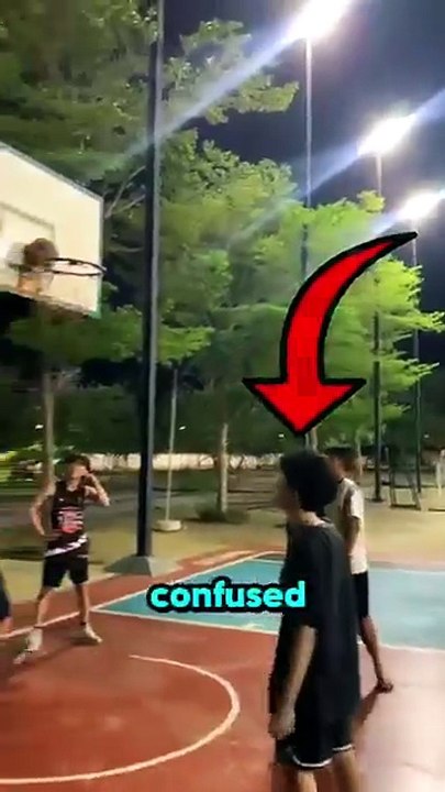A group of boys struggled to retrieve a basketball stuck on the rim, unable to reach it with their jumps.