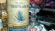 en la oficina entre botanas y bebidas presentando botella de tequila el destilador y tostachos